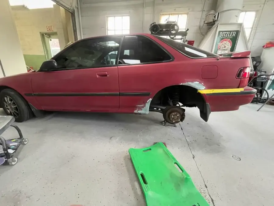 1991 Acura Integra on jack stands for rust repair and welding at the rear wheel arch in Lansdowne, PA