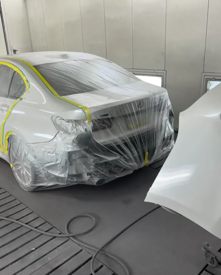 BMW 330i masked with plastic and tape in the paint booth at AG Auto Body and Paint Experts in Lansdowne, PA