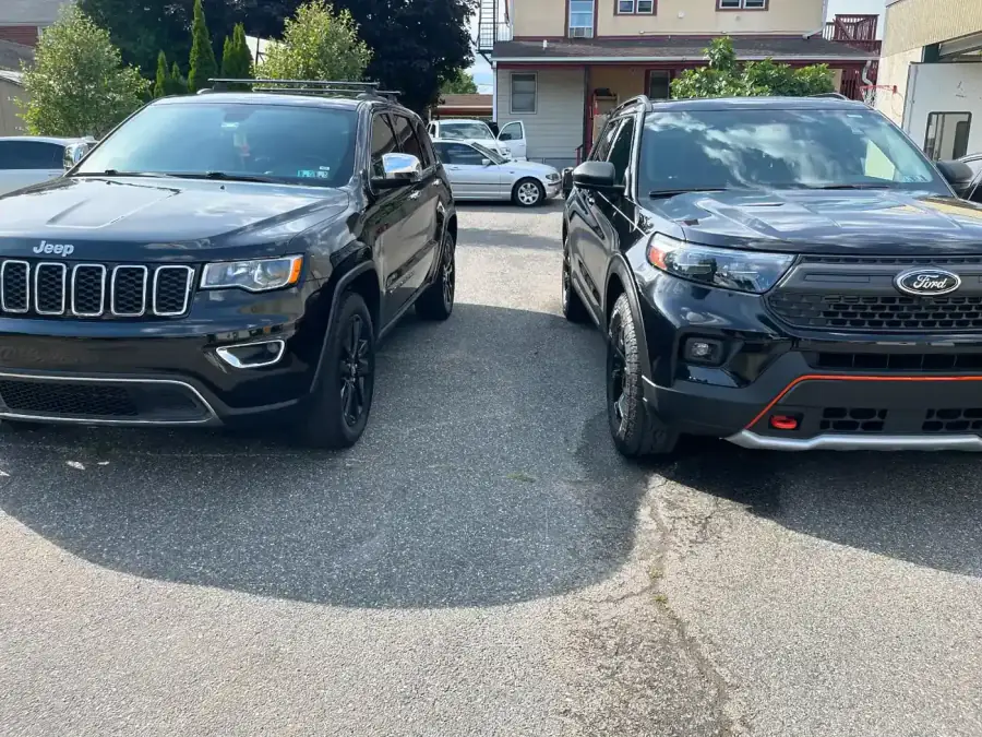 Black Jeep Grand Cherokee and Ford Explorer side by side after collision repair at AG Auto Body and Paint Experts in Lansdowne, PA