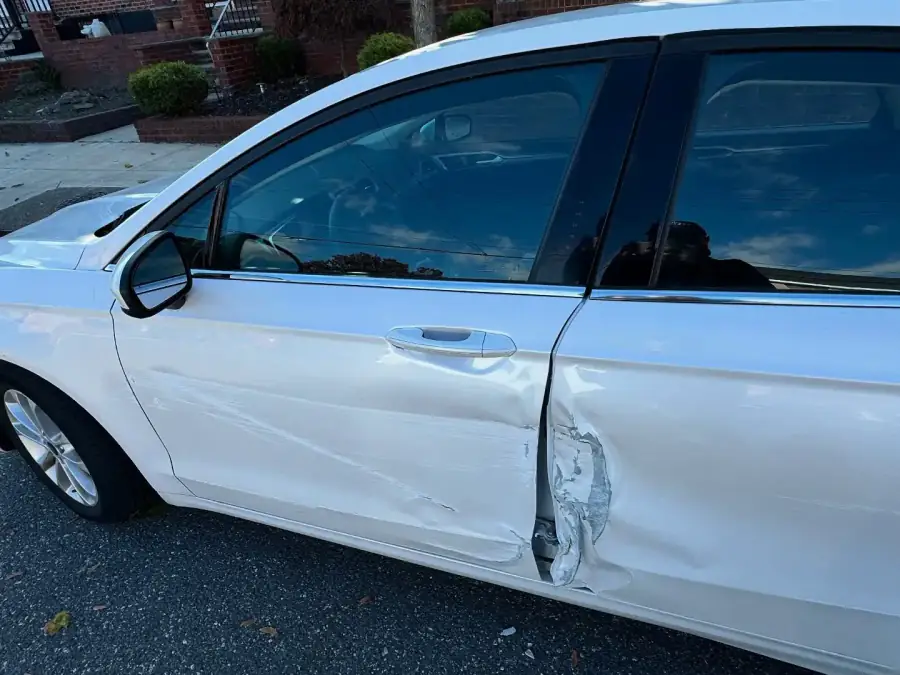 Pearl white Ford Fusion with dented and scraped front and rear doors before collision repair
