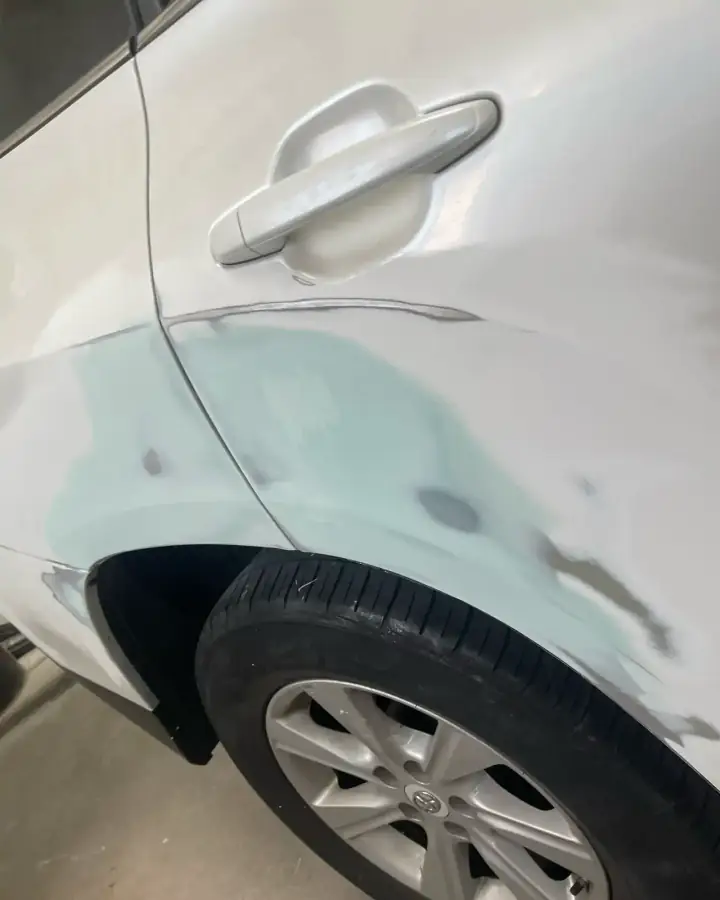 Toyota with three-stage pearl white paint, rear door and quarter panel in primer during repair in Lansdowne, PA